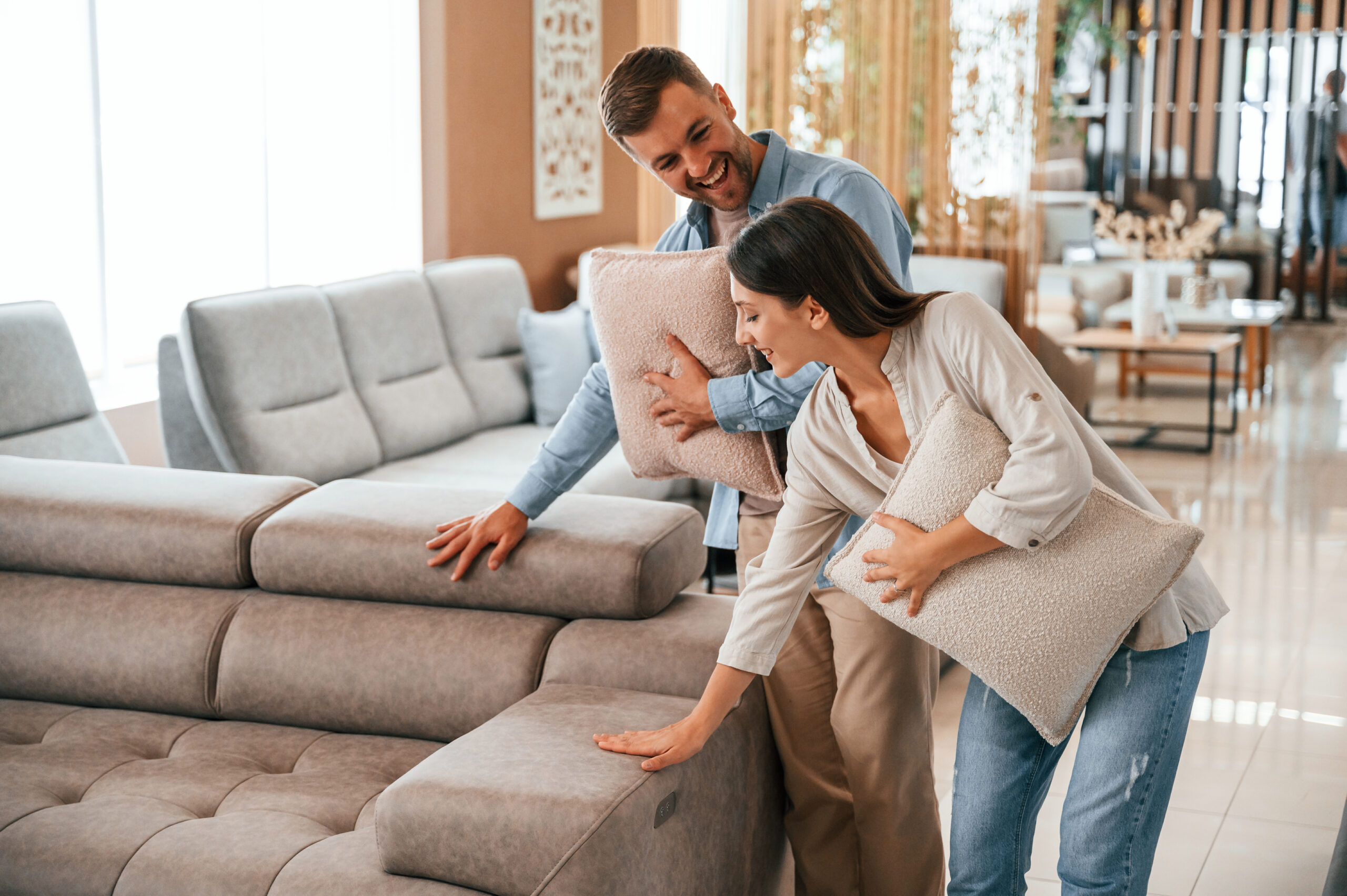 Beautiful product. Couple choosing the sofa and bed in the store